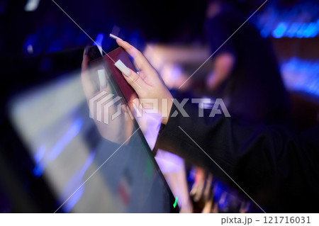 A Close Up Image of a Hand Actively Using a Touchscreen Device in a Dimly Lit Environment A Close Up Image of a Hand Actively Using a Touchscreen Device in a Dimly Lit Environment 121716031