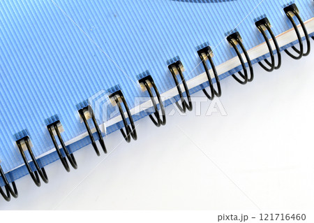 Metal binding in the form of a spring in a school notebook. Metal binding in the form of a spring in a school notebook. 121716460