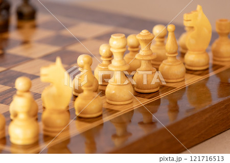 Wooden white chess pieces on the chessboard Wooden white chess pieces on the chessboard 121716513