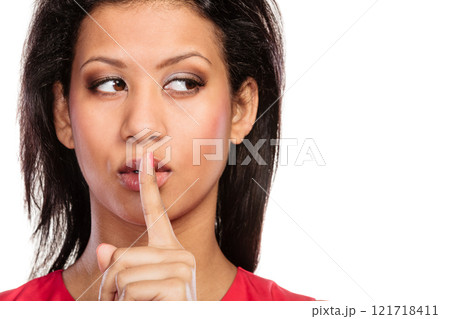 Woman with finger on lips showing silence gesture. 121718411