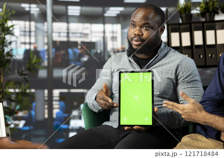 Startup CEO attends meeting to talk about new business vision with executive board member, using chroma key tablet. African american man using mockup device to pitch investment strategy to manager 121718484
