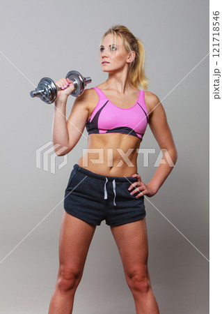 Fit woman lifting dumbbells weights 121718546