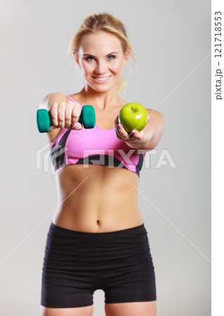 Diet fit body. Girl holds dumbbells and apple fruit 121718553