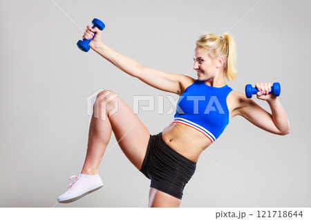 Fit woman lifting dumbbells weights 121718644