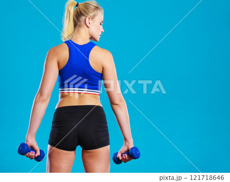 Fit woman lifting dumbbells weights 121718646