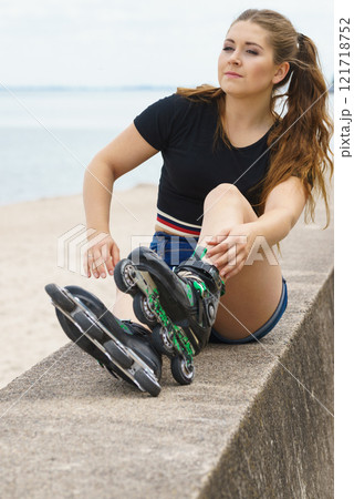 Girl wearing roller skates on seaside Girl wearing roller skates on seaside 121718752