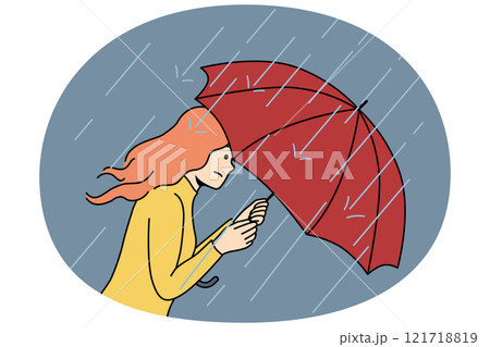 Woman with umbrella rushes home during rain and storm caused by sudden cold snap in autumn 121718819