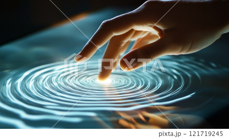 A hand is touching the surface of a touch screen, with ripples visible on its surface. 121719245