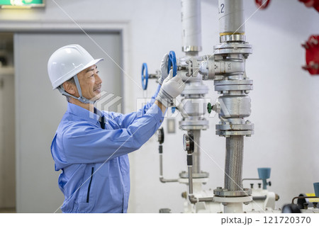 ビルメンテナンススタッフ イメージ 給水設備の点検をするベテランの作業員の横顔 ビルメンテナンススタッフ イメージ 給水設備の点検をするベテランの作業員の横顔 121720370