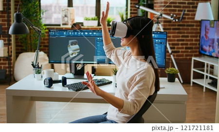 Asian woman engineer creating prototypes with vr glasses and 3D modeling software, working from home to develop new manufacturing gears and turbines. 3D design tech tools. Camera A. Asian woman engineer creating prototypes with vr glasses and 3D modeling software, working from home to develop new manufacturing gears and turbines. 3D design tech tools. Camera A. 121721181
