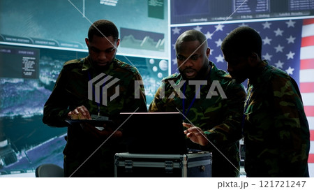 Military officer in a high tech control center engages in cybersecurity operations, protecting classified data from threats and managing digital warfare strategies to maintain state secrets. Camera A. 121721247