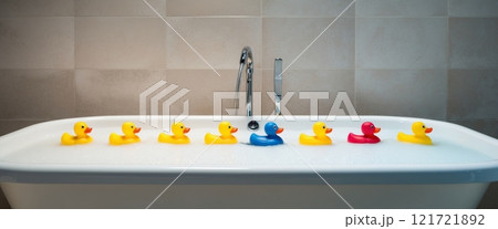 A bathtub filled with bubbles and a line of colorful rubber duckies floating on the water, evoking a sense of fun and playfulness. A bathtub filled with bubbles and a line of colorful rubber duckies floating on the water, evoking a sense of fun and playfulness. 121721892