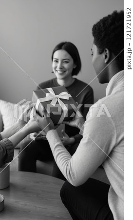 A person presenting a heartfelt thank-you gift, beautifully wrapped with a bow, to a friend. 121721952