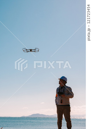 ドローンを使った測量をする作業員 121723454