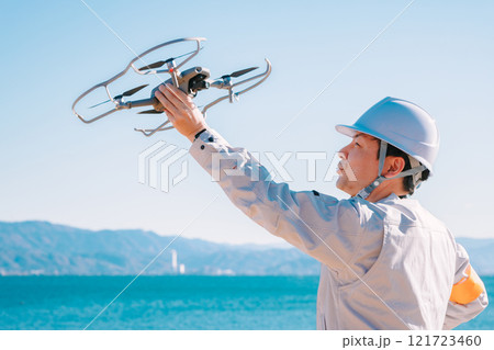 ドローンを飛ばす作業員 121723460