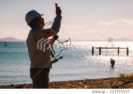 ドローンを使った測量をする作業員 121723537