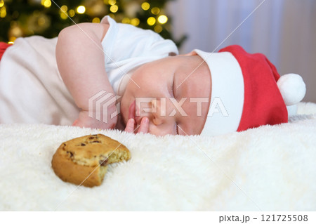 Two-Month-Old Baby in a Christmas Outfit with Milk and Cookies. Selective Focus Two-Month-Old Baby in a Christmas Outfit with Milk and Cookies. Selective Focus 121725508