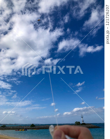 沖縄の綺麗な青空、青い海、ビーチでの冬の凧揚げ(洋凧・カイト) 121726207