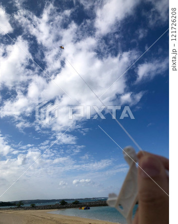 沖縄の綺麗な青空、青い海、ビーチでの冬の凧揚げ(洋凧・カイト) 121726208