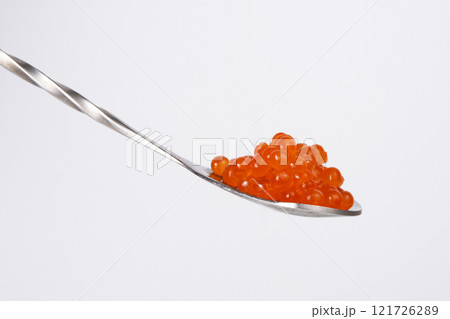 Red caviar in silver spoon isolated on the white background Red caviar in silver spoon isolated on the white background 121726289
