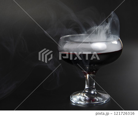 Red beverage cocktail with fume on black background with copy space 121726316