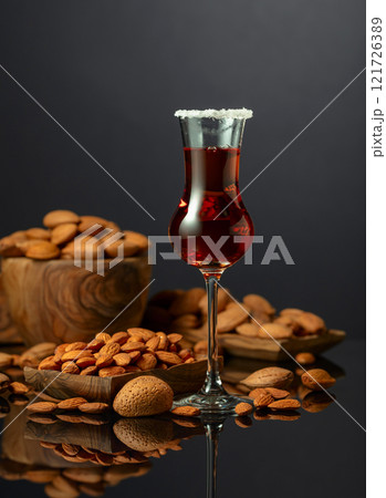 Italian liqueur Amaretto with almonds nuts on a black background. Italian liqueur Amaretto with almonds nuts on a black background. 121726389