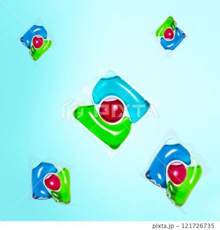 Liquid powder in gel capsule for washing multicolor on blue background 121726735