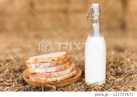Milk bottle and slices of fresh wheat bread on hay Milk bottle and slices of fresh wheat bread on hay 121727672