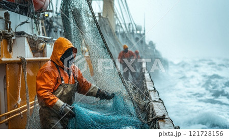 A fisherman catches fish with nets on an industrial fishing vessel in the northern seas. Industrial fishing A fisherman catches fish with nets on an industrial fishing vessel in the northern seas. Industrial fishing 121728156