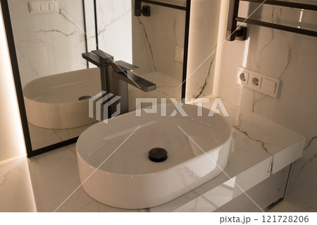 Chrome water faucet and white pedestal sink in bathroom . Stylish bathroom Chrome water faucet and white pedestal sink in bathroom . Stylish bathroom 121728206