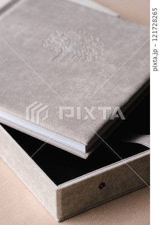 The photo book is grey in a soft cloth cover. the concept of creating books and albums from photographs. professional photographer and printing services 121728265