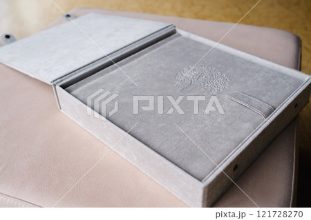 A photo book in a grey cloth cover lies on the box. the concept of creating books and albums from photographs. professional photographer and printing services 121728270