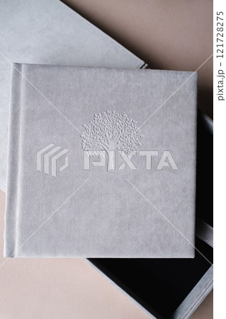 The photo book is grey in a soft cloth cover. the concept of creating books and albums from photographs. professional photographer and printing services 121728275