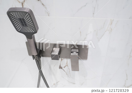 Luxury chrome faucet and shower in shower stall with white marble walls. Modern luxury shower cubicle Luxury chrome faucet and shower in shower stall with white marble walls. Modern luxury shower cubicle 121728329