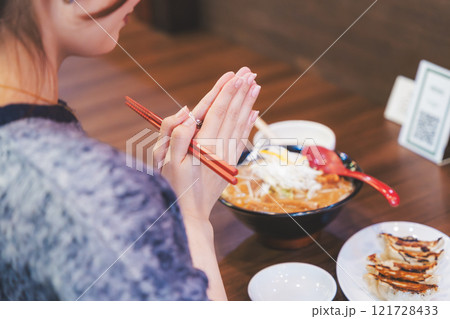 いただきますをしてラーメンを食べる若い女性 121728433