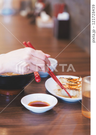 餃子をほおばる若い女性 121728439