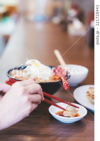 餃子をほおばる若い女性 121728441