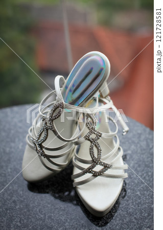 Stylish and highly fashionable woman high heeled shoes with trendy accessories, captured on a colorful background, exuding luxury and elegance perfect for wedding or formal outfit inspiration 121728581