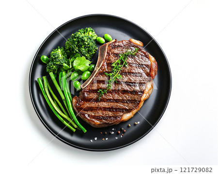 Juicy grilled steak served with fresh broccoli, green beans, and herbs on black plate, creating delicious and appetizing meal, ai generative 121729082