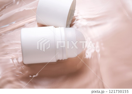 Roll-on deodorant on a pink background in water. Roll-on deodorant on a pink background in water. 121730155