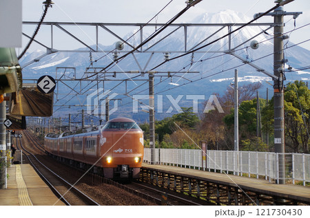 正月連休の旅行客を乗せて冠雪の大山をバックに山陰本線を走る出雲行きの在来線特急電車273系やくも7号 121730430