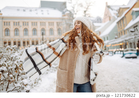 Beautiful woman playing with snow on winter street. Fashion young woman in winter park. Christmas. 121730622
