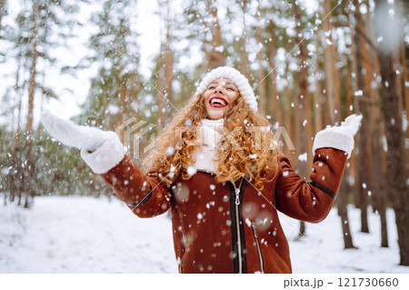 Happy young woman in the winter forest. Christmas, winter holidays concept. 121730660