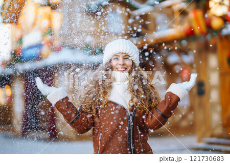 Beautiful woman walking between decorated stalls or kiosks in Christmas market. Travel concept. Beautiful woman walking between decorated stalls or kiosks in Christmas market. Travel concept. 121730683