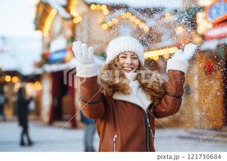Beautiful woman walking between decorated stalls or kiosks in Christmas market. Travel concept. 121730684
