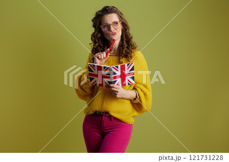 pensive fit woman in sweater and glasses isolated on green pensive fit woman in sweater and glasses isolated on green 121731228