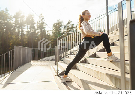 Young woman in sportswear is training outdoors. Sports concept, healthy body. 121731577