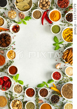 A lively frame of assorted herbs and spices on gray, highlighting the vibrant colors and flavors for cooking inspiration, top view and copy space A lively frame of assorted herbs and spices on gray, highlighting the vibrant colors and flavors for cooking inspiration, top view and copy space 121731779