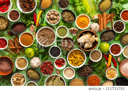A vibrant assortment of fresh, multicolored spices and herbs on a delicate green background, perfect for cooking and culinary inspiration A vibrant assortment of fresh, multicolored spices and herbs on a delicate green background, perfect for cooking and culinary inspiration 121731781