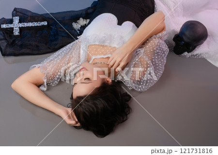 Elegant woman poses in alluring corset and lingerie with unique accessories 121731816